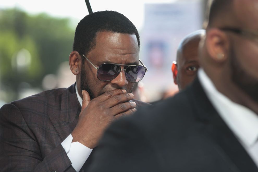 CHICAGO, ILLINOIS - JUNE 26: R&B singer R. Kelly covers his mouth as he speaks to members of his entourage as he arrives at the Leighton Criminal Courts Building for a hearing on June 26, 2019 in Chicago, Illinois. Kelly is facing several counts of aggravated sexual abuse