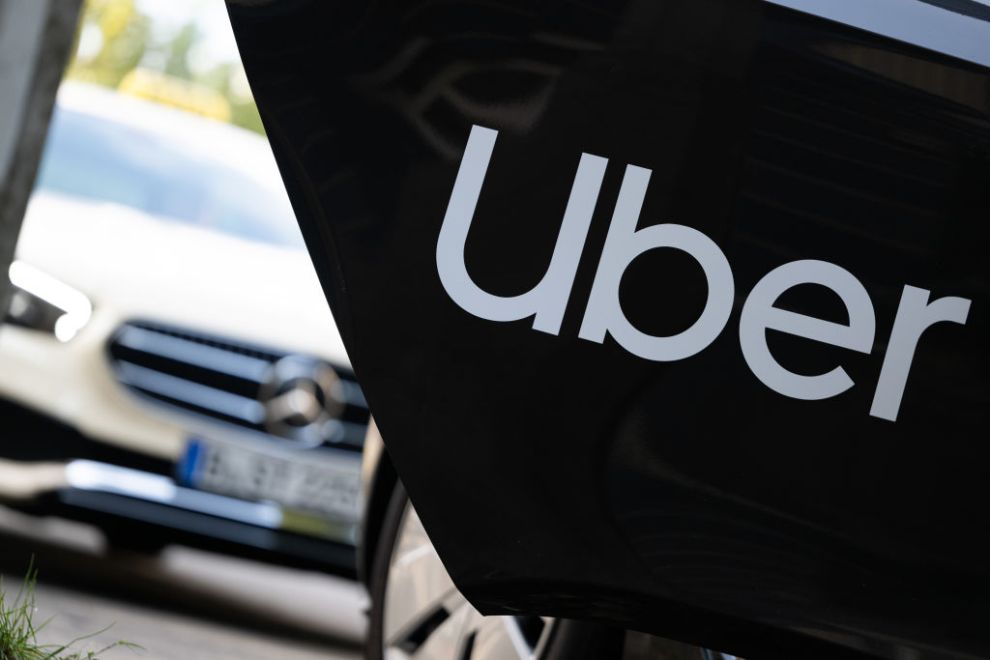 ILLUSTRATION - 08 August 2024, Berlin: A rental car with a sign from the mobility service provider and ride broker Uber stands in front of a cab that can also be booked through the company. Photo: Sebastian Gollnow/dpa